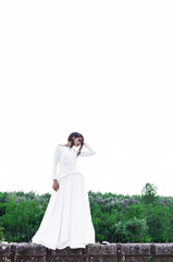 Fototapeta premium Woman posing in nature wearing long white dress