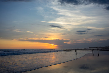 Fototapeta premium people on tropical beach at sunset