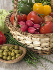 fresh vegetables with olives on a wooden table. 