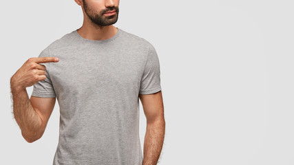 Design and advertising concept. Horizontal shot of fashionable unshaven male points with fore...