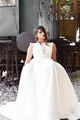 Naklejka premium Girl sitting next to old train in white dress