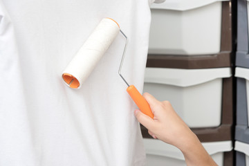 Hand holding a pet hair remover cleaning pet's hair on shirt