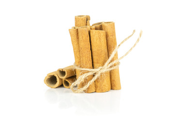 Lot of whole dry brown cinnamon stick tied by jute isolated on white background