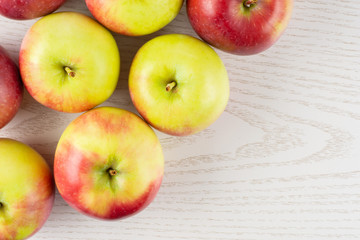 Lot of whole fresh red apple james grieve variety flatlay on grey wood