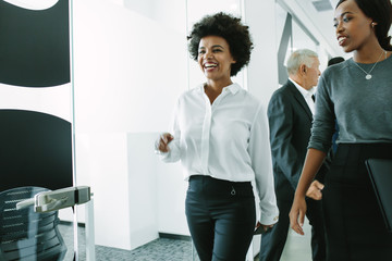 Woman with colleagues walking through office corridor