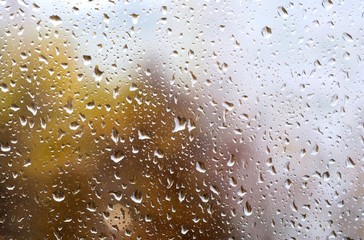 Raindrops on the glass in the autumn time. View through the window