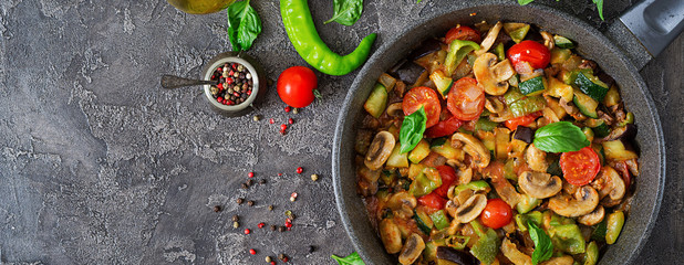 Hot spicy stew eggplant, sweet pepper, tomato, zucchini and mushrooms. Flat lay. Top view. Banner