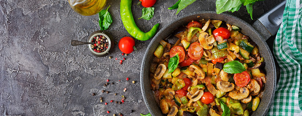 Hot spicy stew eggplant, sweet pepper, tomato, zucchini and mushrooms. Flat lay. Top view. Banner