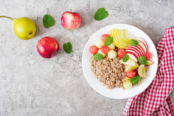 Healthy breakfast. Buckwheat or porridge with fresh melon, watermelon, apple and pear. Tasty food. Top view, copy space, flat lay