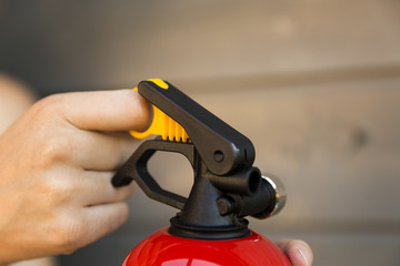 Hand pulling pin of fire extinguisher. Safety concept