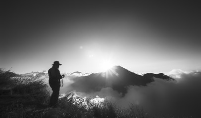 Unidentified hiker takes photo on their way to the summit of mount Rinjani, Lombok, Indonesia in black and white