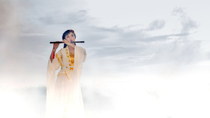 Chinese girl is playing the traditional Chinese musical instrument on the boats in the  lake  Asia young woman play flute in the nature. © Sirirat Makprasert