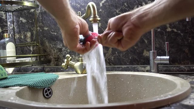 The fork is washed in a sink under a water stream
