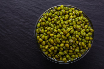fresh Mung beans on a dark stone background