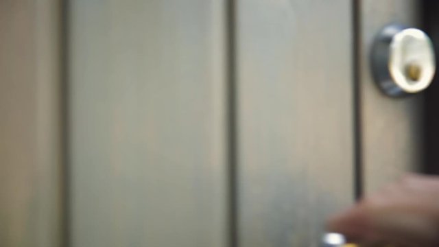 Woman unlocking entrance door with a key. Person using key and locking door. Real estate  security concept