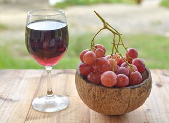 red grapes and a glass of wine on wooden table. selective focus.