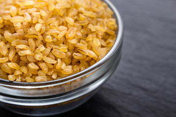 raw bulgur on a dark stone background