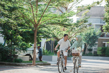 couple holding hands while ride a bike
