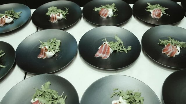 Chef preparing and decorating food, many round plates&nbsp;with meal in kitchen in restaurant
