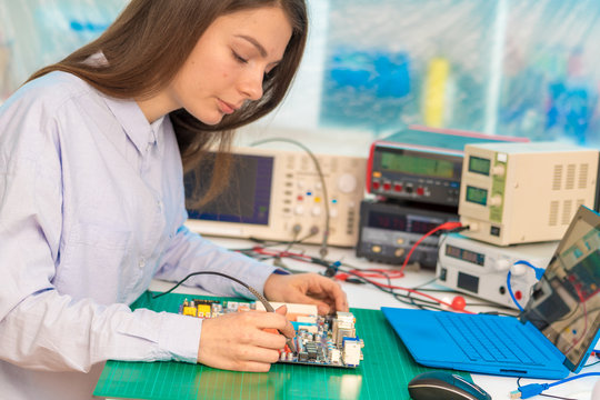 Female student in electronics class uses a Measuring device