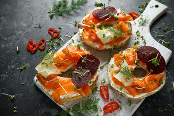 Smoked salmon bagel toasts with soft cheese, cucumber ribbons and beetroot and dill, cress salad