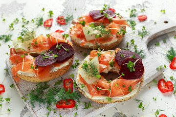 Smoked salmon bagel toasts with soft cheese, cucumber ribbons and beetroot and dill, cress salad