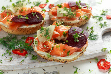 Smoked salmon bagel toasts with soft cheese, cucumber ribbons and beetroot and dill, cress salad