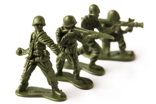 Four green toy plastic soldiers, isolated on white background