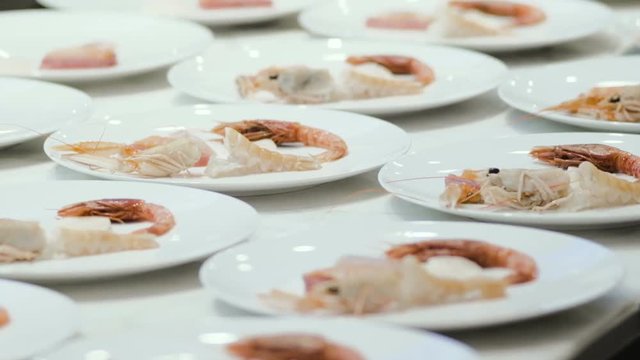 Chef preparing and decorating food, many round plates&nbsp;with meal in kitchen in restaurant
