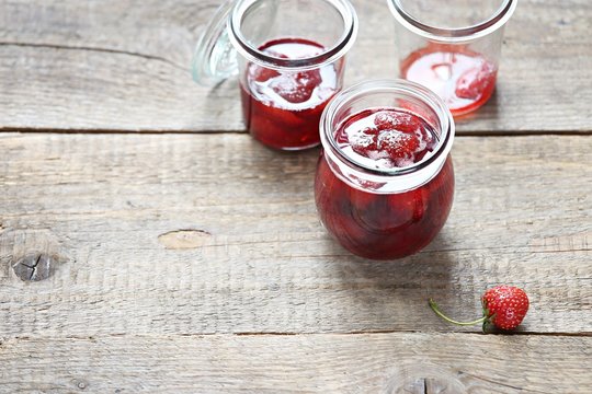 Strawberry marmalade. Homemade strawberry jam in glass jar overhead rustic wooden table. Copy space