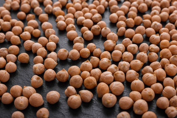 uncooked chickpeas on a dark stone background