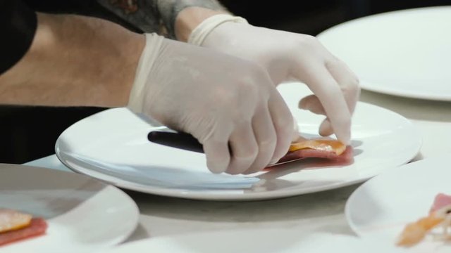 Chef preparing and decorating food, many round plates&nbsp;with meal in kitchen in restaurant
