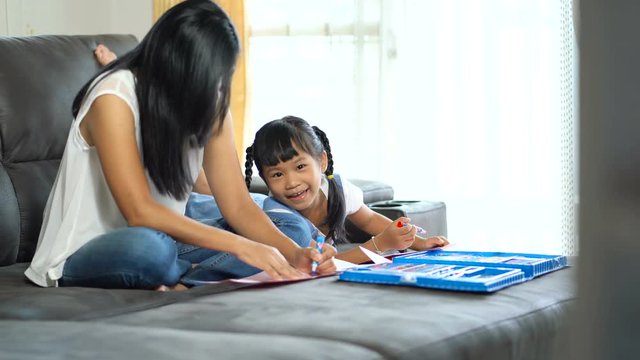 Asian family, mother and daughter are painting happily.