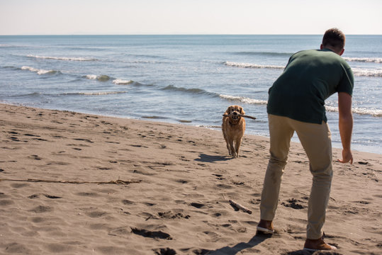 Man With Dog Enjoying Free Time On The Beach