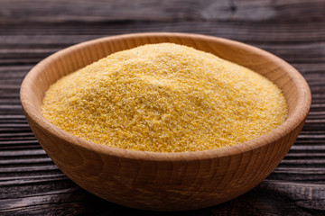 raw Italian corn porridge polenta on a rustic wooden background