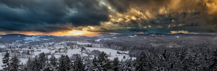 Sonnenuntergang über der verschneiten Winterlandschaft bei Neuschönau, Bayern, Deutschland.