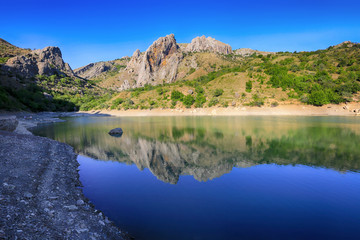 A beautiful mountain lake, where the mountains are reflected in the water in Zelenogorye, Crimea