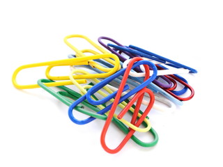 Lot of colorful paper clips and office pins on white background. Side view