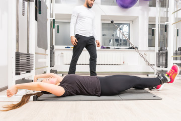Fototapeta premium Woman exercising legs on cable machine at gym