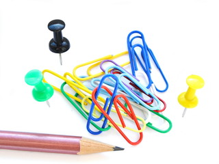 colorful sharp pencil, paper clips and office pins on white background