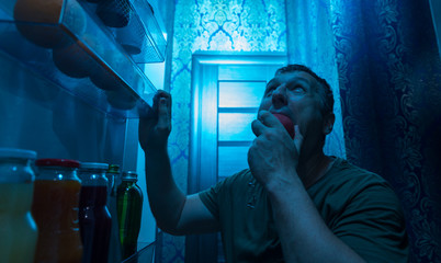 Hungry man looking for a snack in his fridge