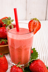 fresh strawberrysmoothie or milkshake on a wooden rustic background