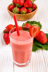 fresh strawberrysmoothie or milkshake on a wooden rustic background