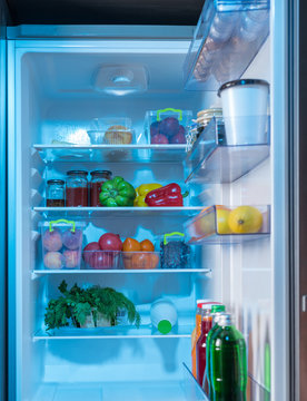 Open fridge with healthy fresh food inside