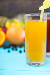 Glass of orange fresh juice with plastic straw