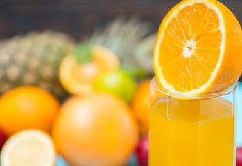 Half of orange on glass with fresh juice