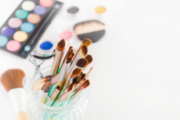 Colorful cosmetic set with brushes and objects of cosmetics on white background