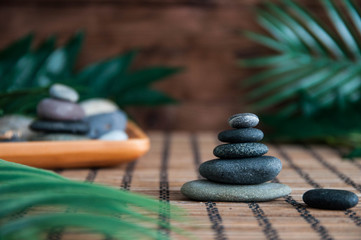 Pyramids of gray zen stones with green leaves . Concept of harmony, balance and meditation, spa, massage, relax