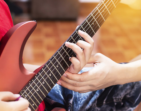 Father hands his son to play red guitar.