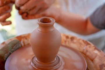Fototapeta na wymiar The master's hands make a pot on the potter's wheel.